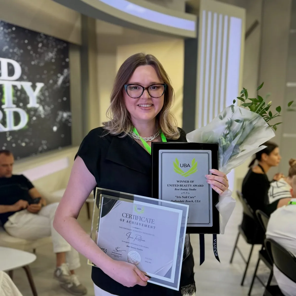 Irina holding the United Beauty Award for Best Beauty Studio