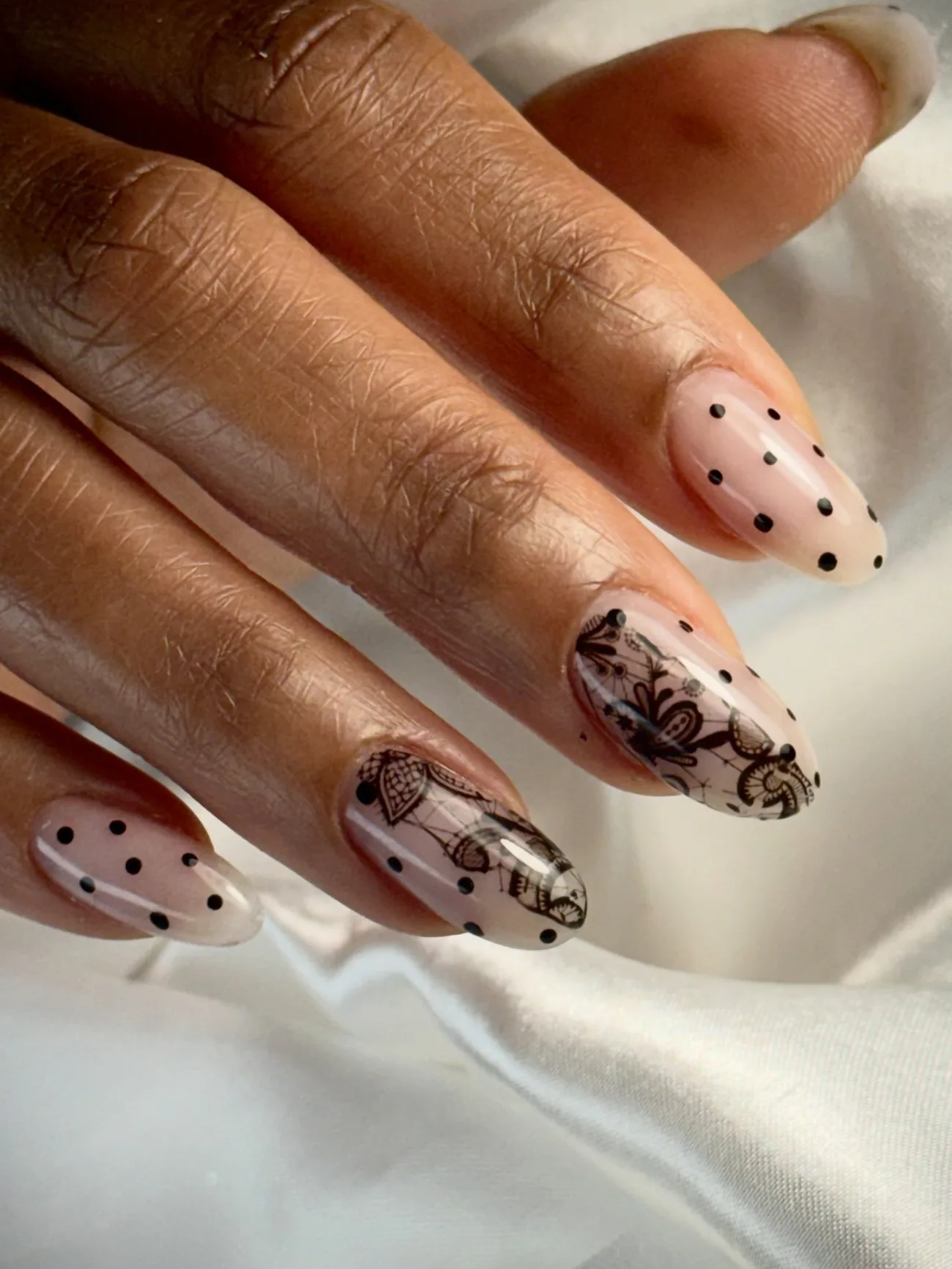 Black lace and dot art hand-painted on nude nails